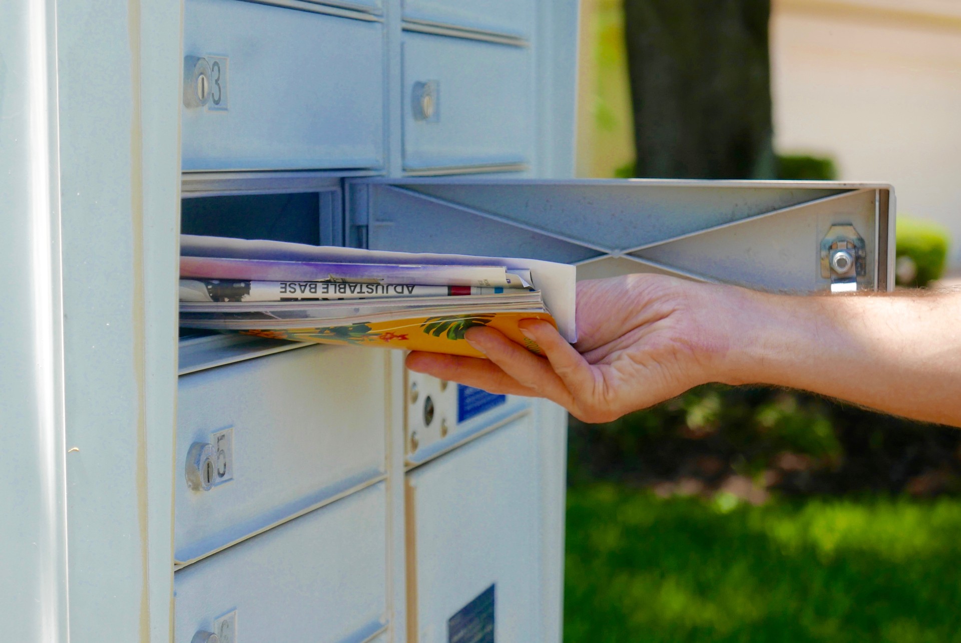 Person's hand pulling mail out of a mailbox